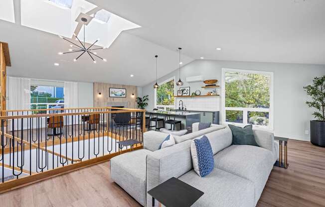 A modern living room with a grey couch and a black coffee table.