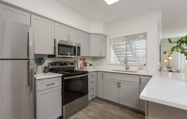 a kitchen with white cabinets and stainless steel appliances