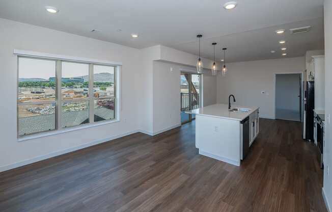 a living room with a large window and a kitchen with a island at The Crossings at Windsong, Prescott Valley