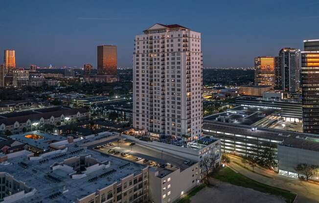 an aerial view of apartment building in the middle of a city at night at Dominion Post Oak in Houston, TX