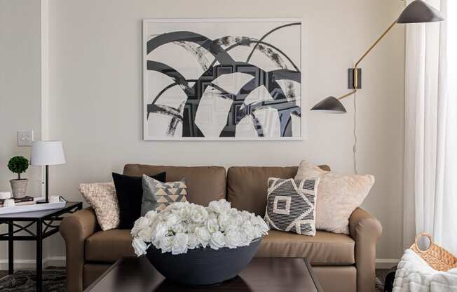 a living room with a couch and a coffee table with a vase of flowers on it