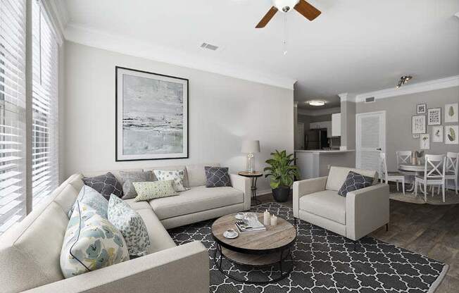 a living room filled with furniture and a ceiling fan