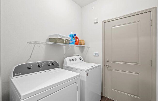a laundry room with a washer and dryer next to a door