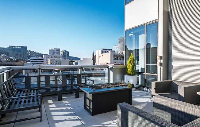 A patio with black furniture and a view of the city.