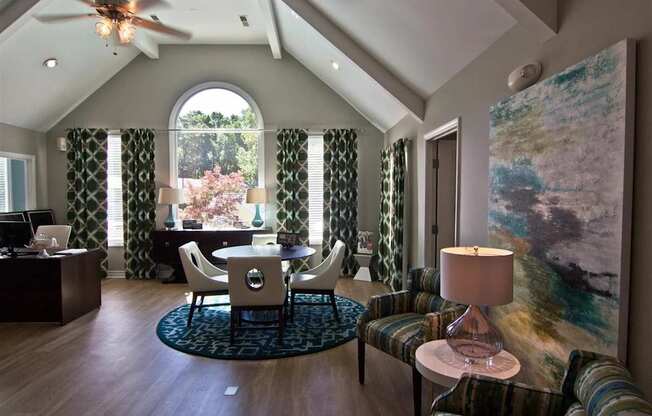 A room with a ceiling fan and a painting on the wall.