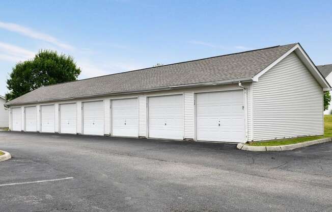 a white garage with white doors on the side of a building