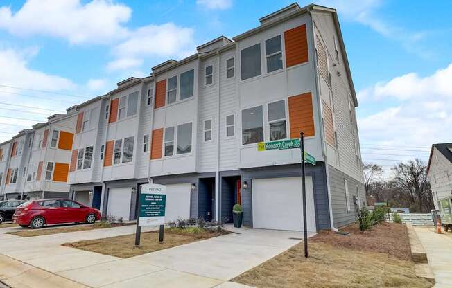 A modern apartment building with a red car parked in front.