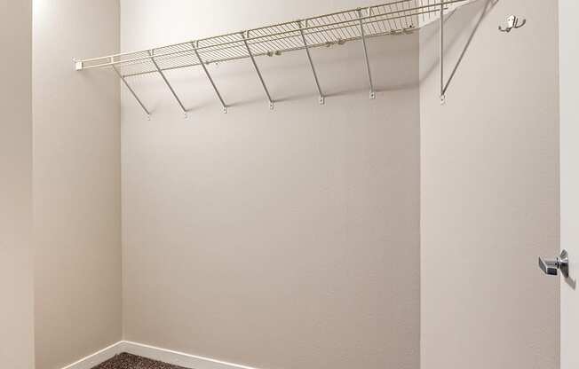 an empty closet with a hanging rack on the wall