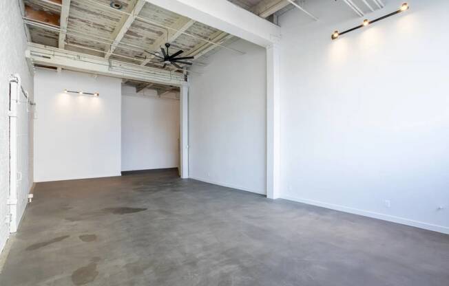 an empty room with white walls and a ceiling fan