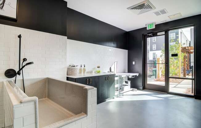 a kitchen with a sink and a tub and a door to a surgery room