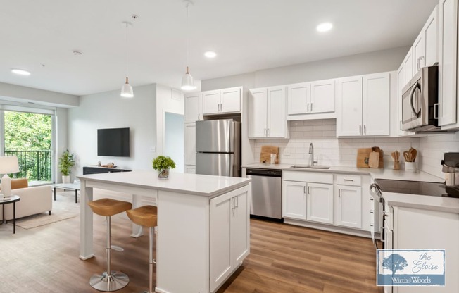 a large white kitchen with an island and stainless steel appliances