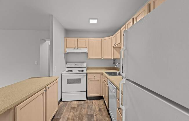 A kitchen with wooden cabinets and a white stove top oven