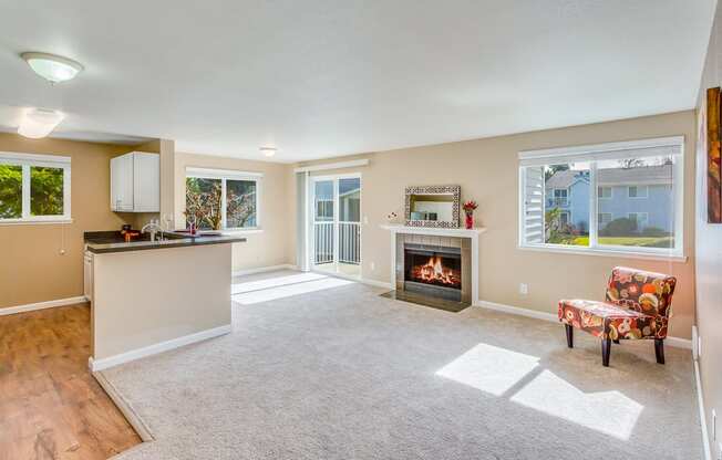 an empty living room with a fireplace and a kitchen at Springfield, Renton, WA 