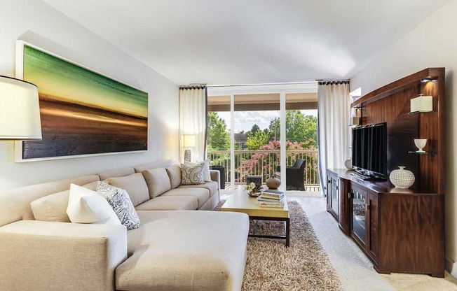 A living room with a large couch and a painting on the wall.