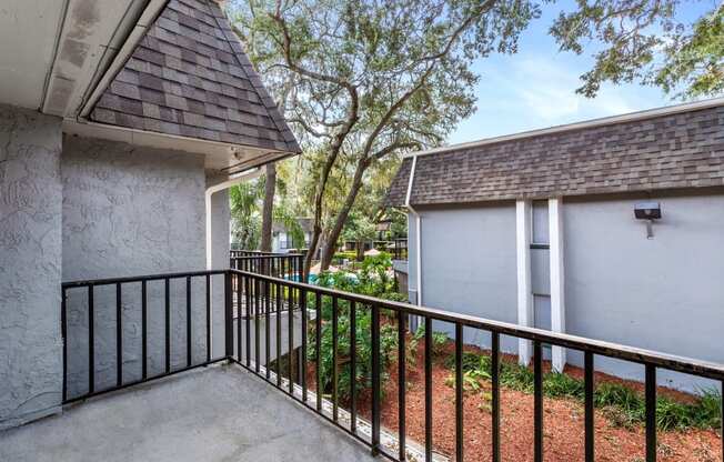 a balcony with a white house and a tree