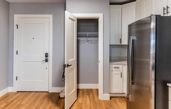 a kitchen with white cabinets and a stainless steel refrigerator