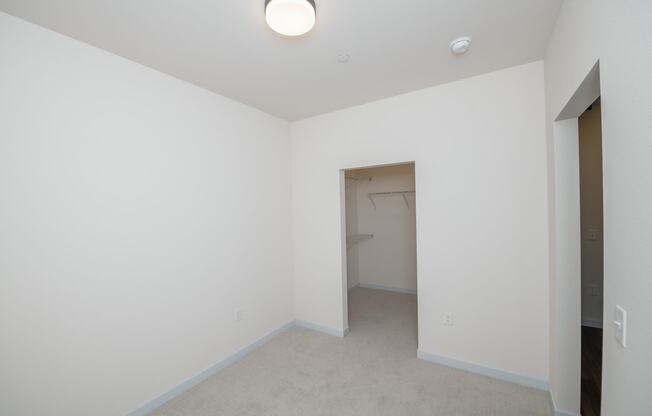 an empty room with white walls and a closet at The Crossings at Windsong, Prescott Valley, Arizona