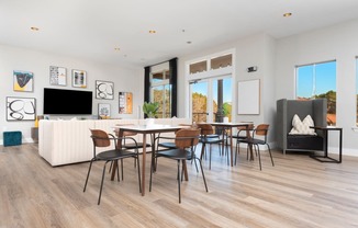 a living room with a table and chairs and a couch in the background