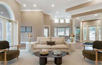 A living room with a white couch and a coffee table in the middle.