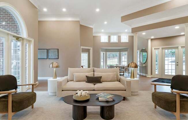 A living room with a white couch and a coffee table in the middle.