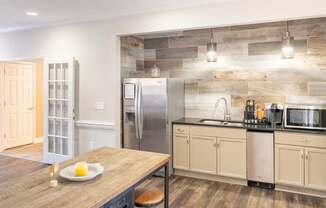 A kitchen with a wooden table and a refrigerator.