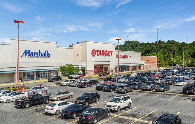 a parking lot filled with cars in front of a shopping mall