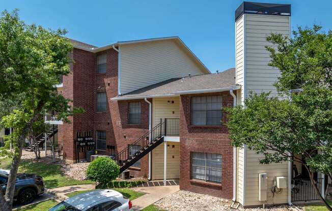 A two-story apartment building with a brick facade and a white exterior.