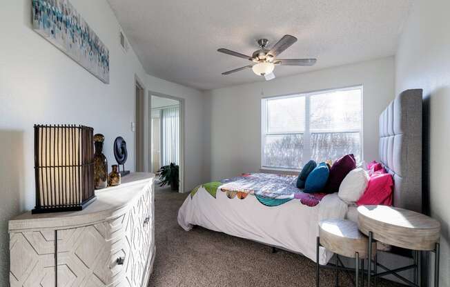 a bedroom with a bed and a ceiling fan