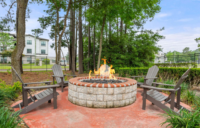 fire pit with chairs and a table and trees at Villages of Cypress Creek, Texas