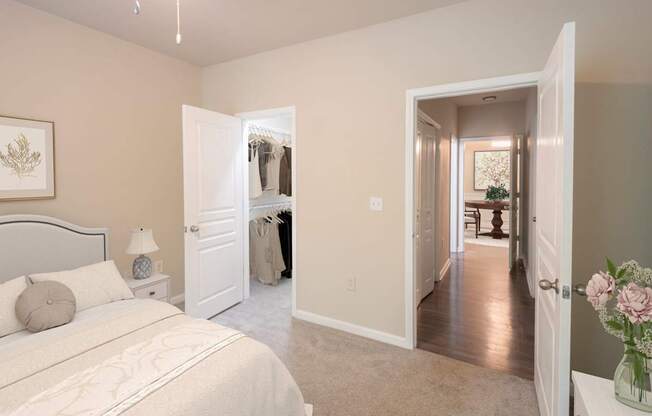 A bedroom with a large bed and a hallway leading to another room.
