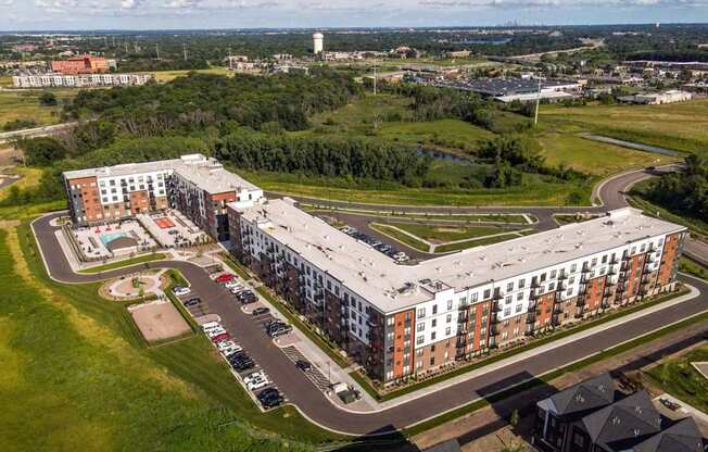 A large apartment complex with a parking lot in front.