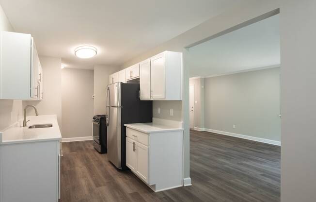 a kitchen with white cabinetry and a black refrigerator