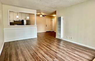 an open living room and kitchen with wood flooring