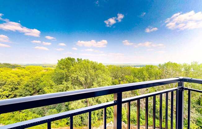 a balcony with a view of trees and a blue sky