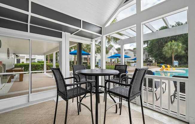 A table with four chairs is on a patio.
