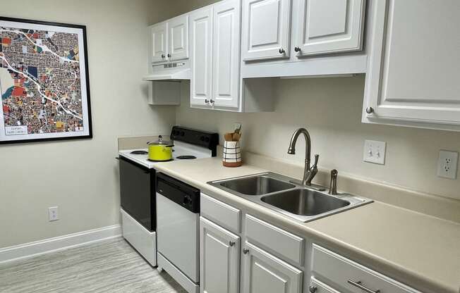 a kitchen with white cabinets and a black dishwasher