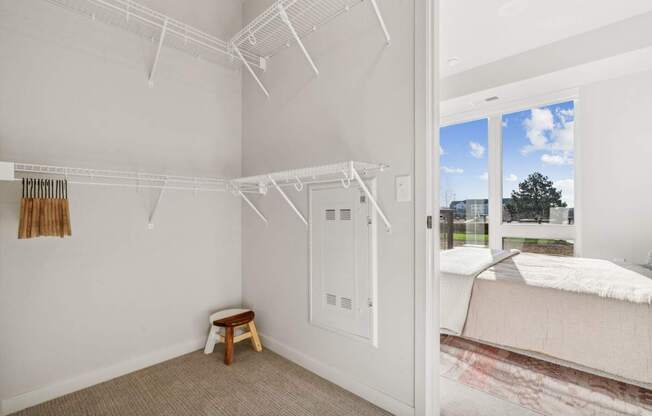 A white bedroom with a bed and a small table.
