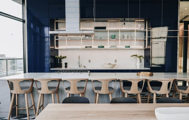 a large kitchen with a long table and chairs in front of a window at The Lively, Jersey City