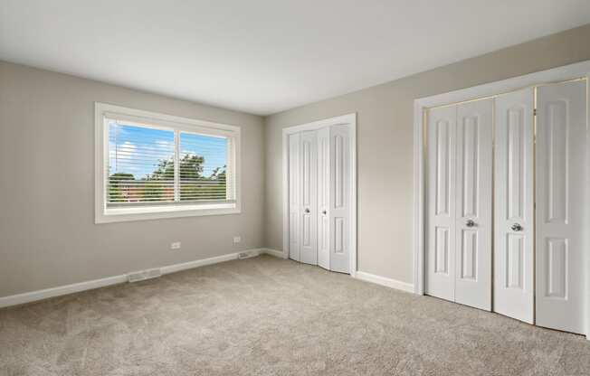 a bedroom with two closets and a window at The Hinsdale, Hinsdale, 60521