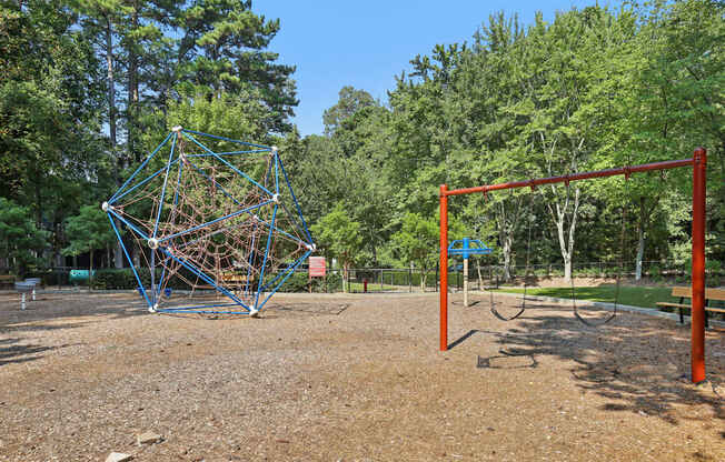 A playground with a swing set and a climbing structure.