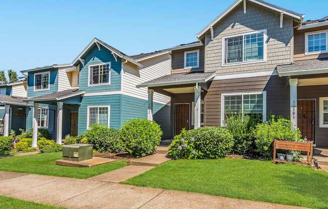 A row of townhomes with green bushes in front at The Landing Apartments and Townhomes, Oregon, 97045