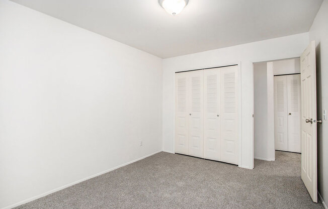 an empty bedroom with a large closet