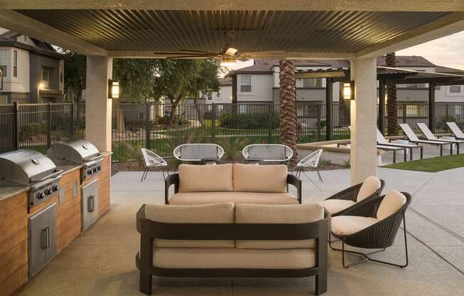a patio with a couch and chairs and a grill