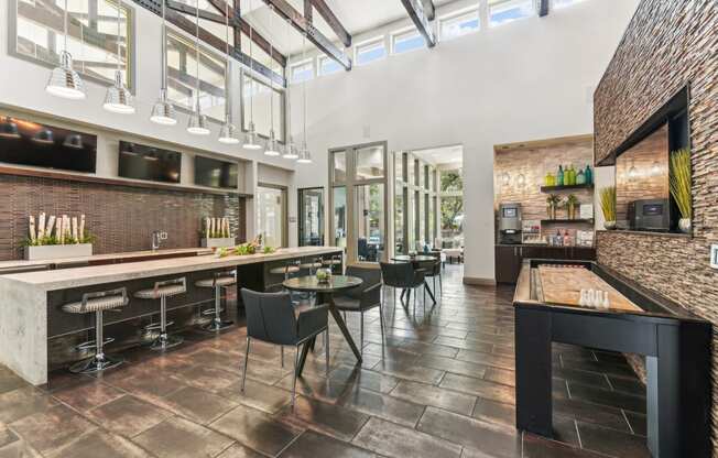 a dining area with tables and chairs and a bar and a kitchen