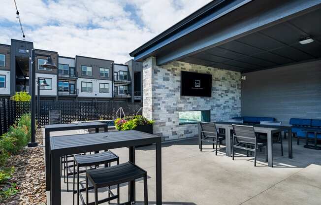 a patio with tables and chairs and a building in the background