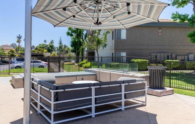 a patio with a bench and an umbrella