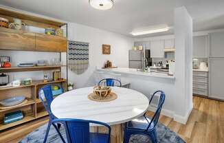 A kitchen with a dining table and chairs.
