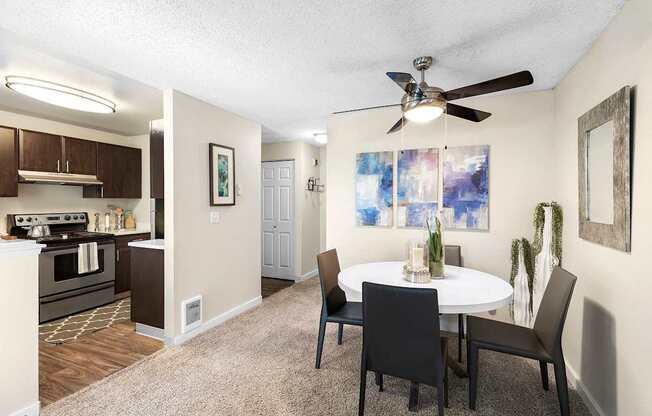 A dining room with a white table and chairs.