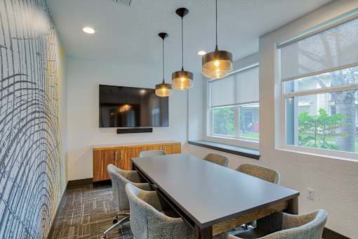 A conference room with a long table and chairs.