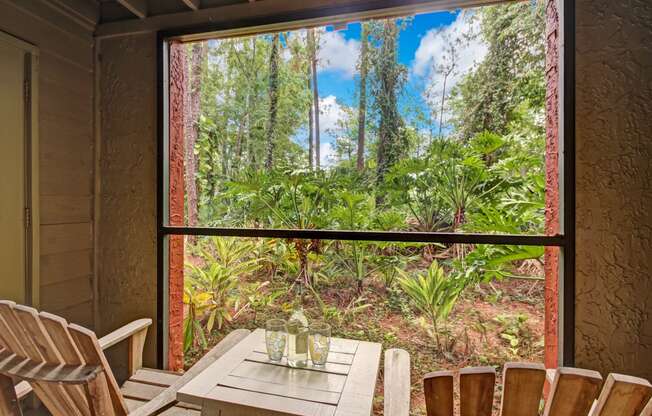 a room with a table and chairs and a large window